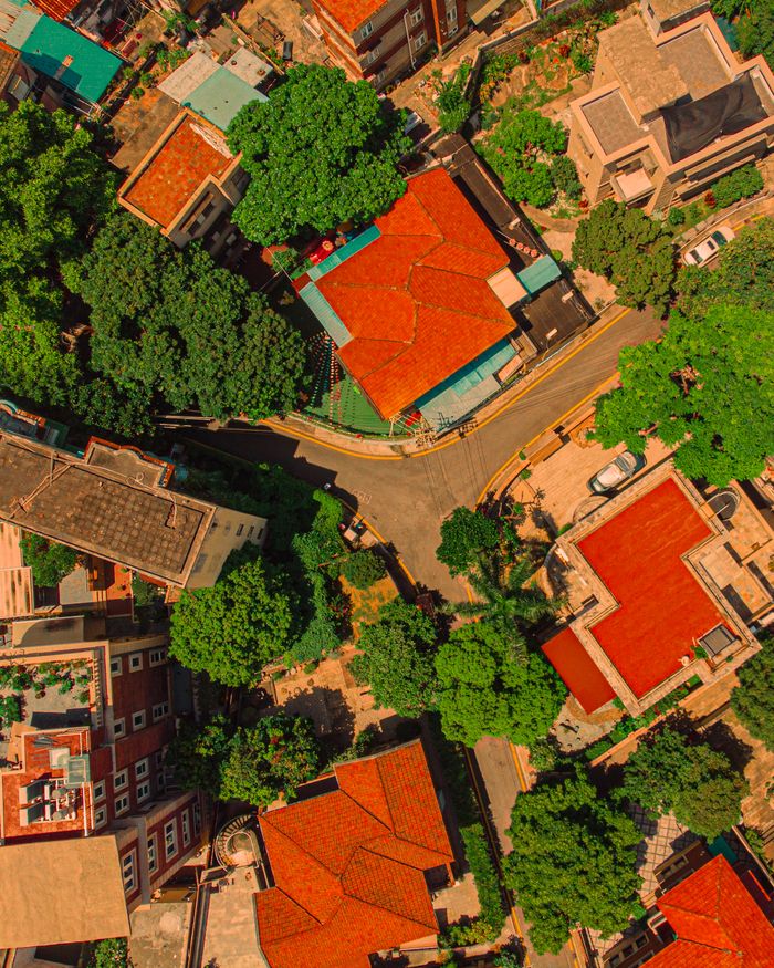 services-03 Stunning aerial view of a vibrant residential neighborhood surrounded by lush trees and vibrant rooftops.